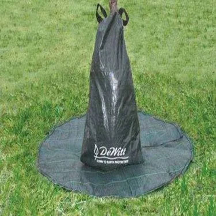 DeWitt tree watering bag installed around a tree trunk over a black mulch ring on a lawn.