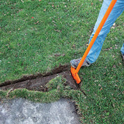 Closeup of half-moon turf edger cutting a defined edge along a concrete walkway.