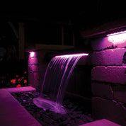 Color Changing Colorfalls LED Waterfall: Purple light illuminating modern backyard water feature.
