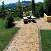 Tan and gray patio pavers create a relaxing outdoor space with lounge chairs, overlooking a scenic mountain view.

