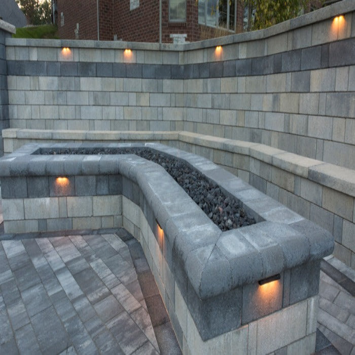 Stonegate Contemporary Cap Smooth fire pit kit:  curved design, gray concrete blocks, built-in seating, & integrated lighting.
