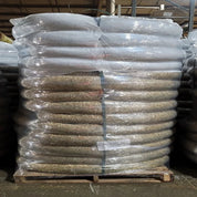 Large bale of straw wattles, shrink-wrapped on a wooden pallet.
