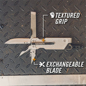 Multi-tool with interchangeable blade and textured grip, shown open on a metallic surface.
