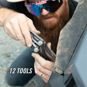 Close-up of hands using a multi-tool with twelve implements to repair a vehicle.
