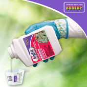 Garden gloves pouring concentrate from Eight insect control bottle into measuring cup for vegetable, fruit, and flower application.
