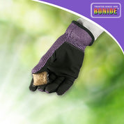 Hand in purple gardening glove holding mosquito dunks outdoors.
