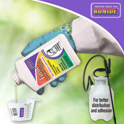 Pouring spreader sticker concentrate into measuring cup for garden application.
