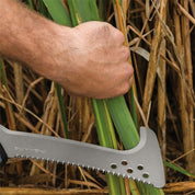 Hand using billhook to cut thick reeds.
