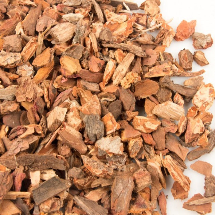 Small, reddish-brown bark nuggets for landscaping, close-up view.
