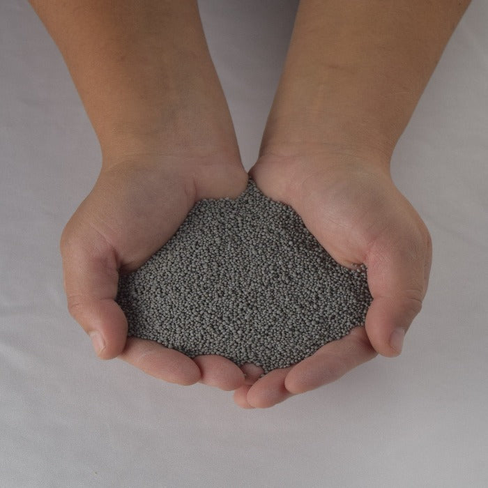 Hands cupping gray MicroClover seed for lush lawns.
