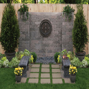 Serene backyard patio with stone wall, decorative accents, and stone path.

