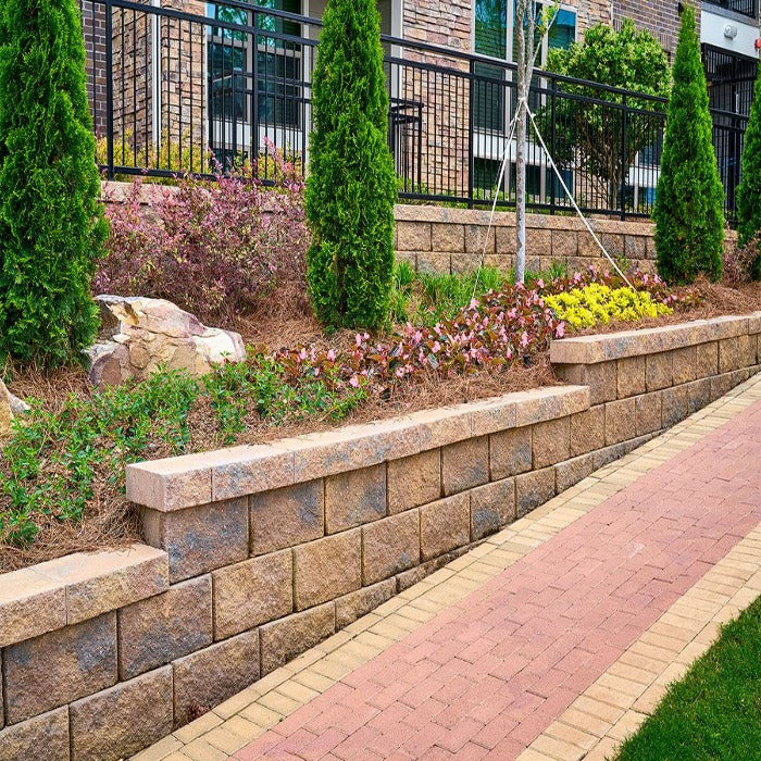 Regal Stone Pro Straight retaining wall, multi-toned brown blocks, landscaped setting.
