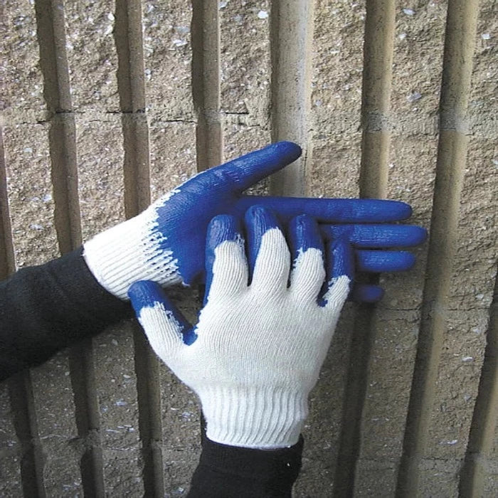 White cotton work gloves with blue nitrile coating, shown against a textured wall.
