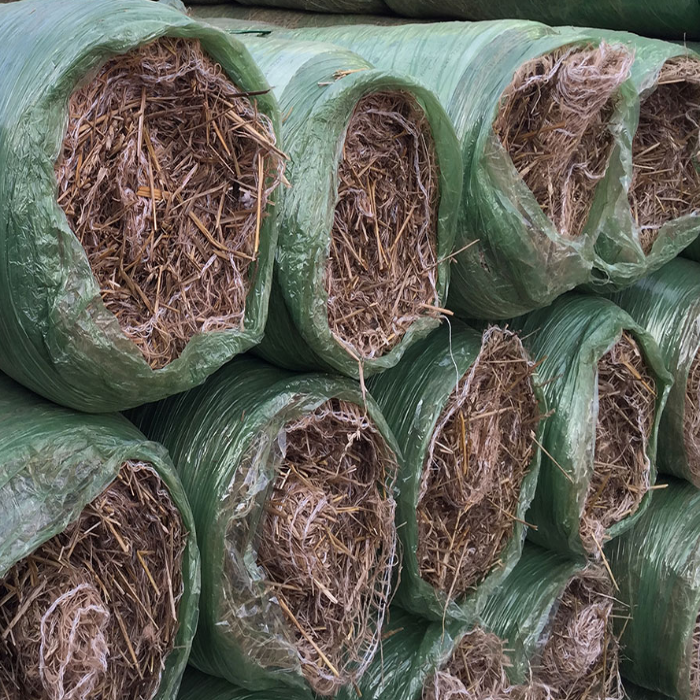 Straw-Coconut Erosion Control: Biodegradable straw rolls in green plastic packaging for land stabilization.
